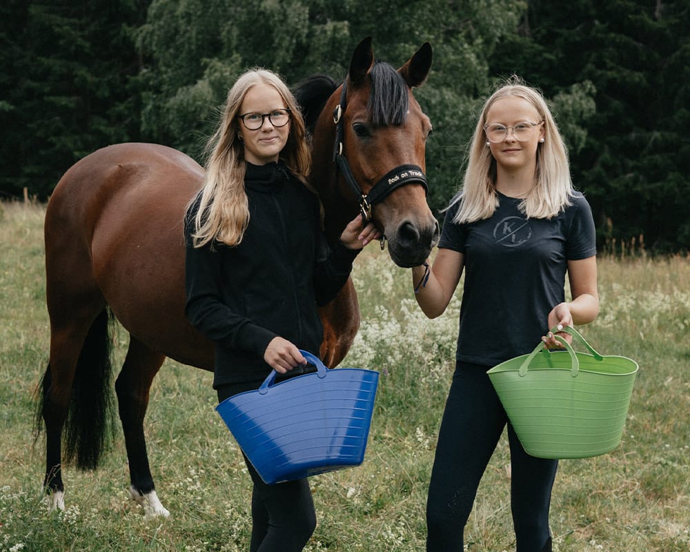 Två tjejer i hagen med sin häst